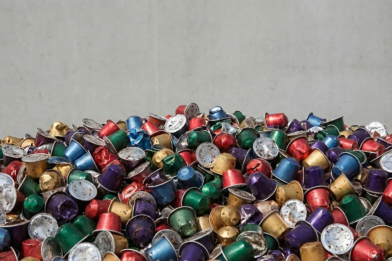 Haufen gebrauchter Aluminium-Kaffeekapseln – das Müllproblem der Kapselsysteme