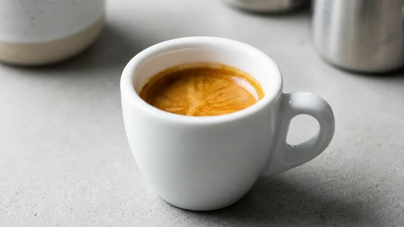 Espresso Shot mit goldener Crema in kleiner Porzellantasse