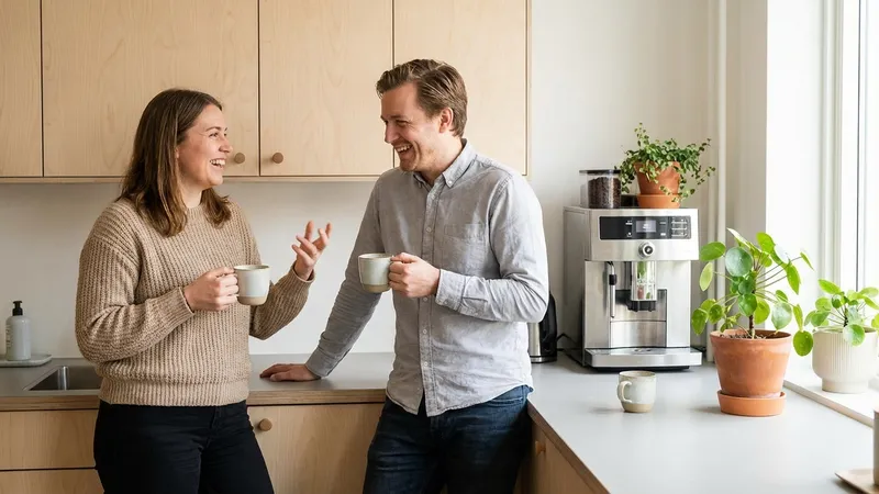 Zwei Kollegen im Gespräch bei einer Tasse Kaffee in der Büroküche